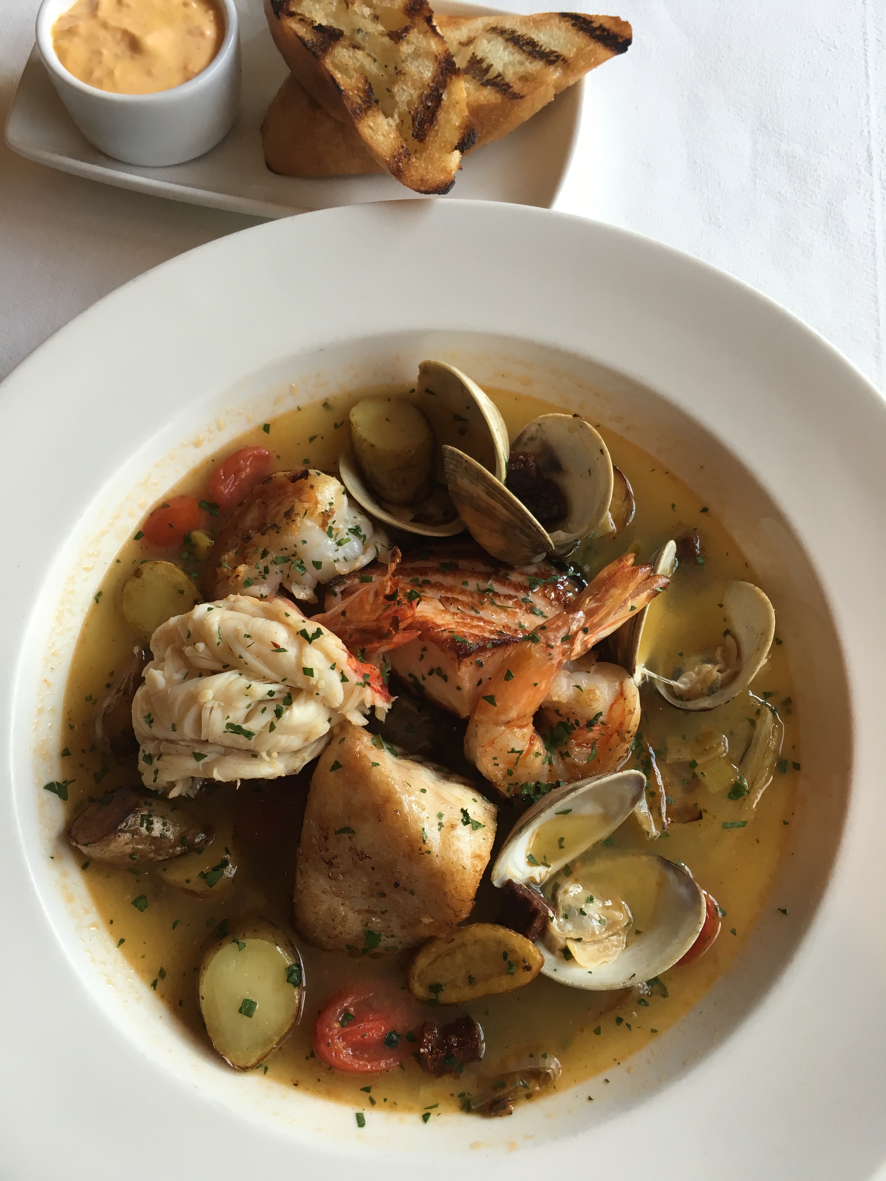 Bouillabaisse prepared with Alaskan Halibut, Bay of Fundy Salmon, White Shrimp, Littleneck Clams and a Lobster Tail.